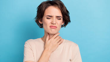 image représentant une femme qui se tient la gorge