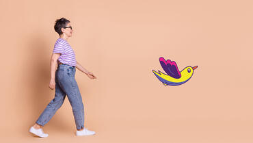 Personne qui marche avec le dessin d'un oiseau multicolore devant elle