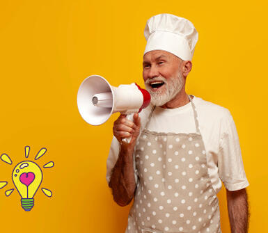 Homme en tablier avec une toque parlant dans un megaphone