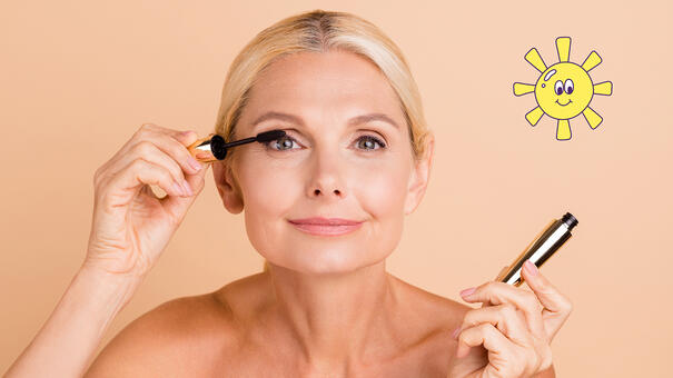 Femme blonde se maquillant les cils