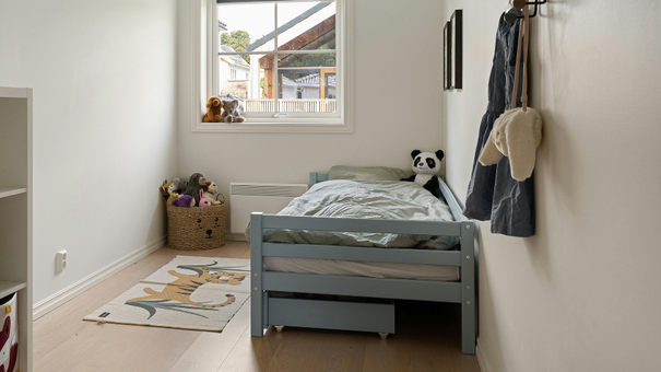 chambre d'enfant avec un lit simple, un tapis et une fenêtre 