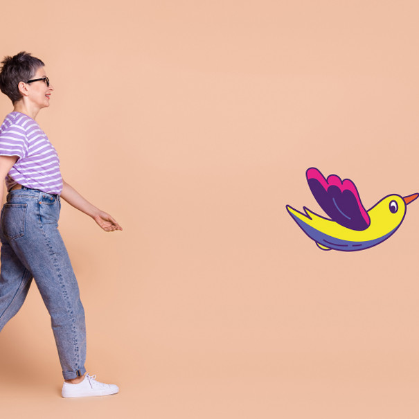Personne qui marche avec le dessin d'un oiseau multicolore devant elle