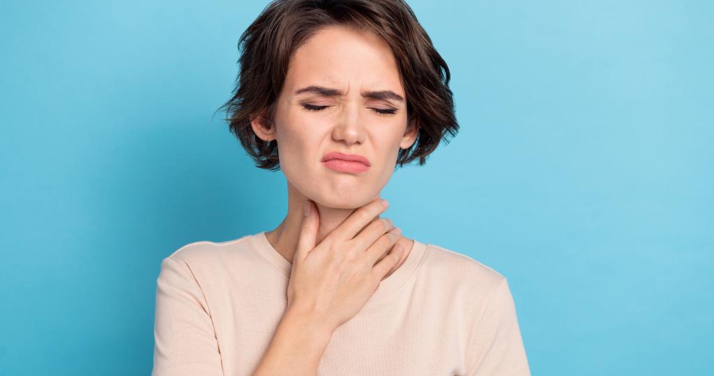 image représentant une femme qui se tient la gorge