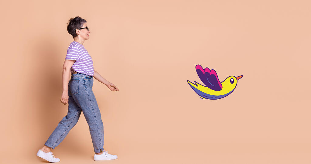 Personne qui marche avec le dessin d'un oiseau multicolore devant elle