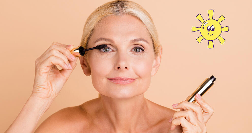 Femme blonde se maquillant les cils