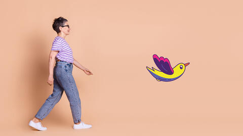 Personne qui marche avec le dessin d'un oiseau multicolore devant elle